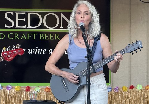 Ché performing live, singing and playing guitar