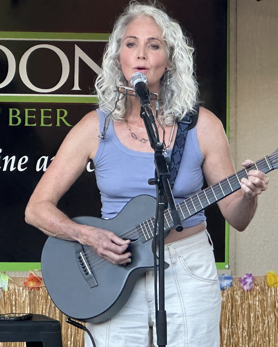 Ché performing live with guitar and vocals at a Sedona venue